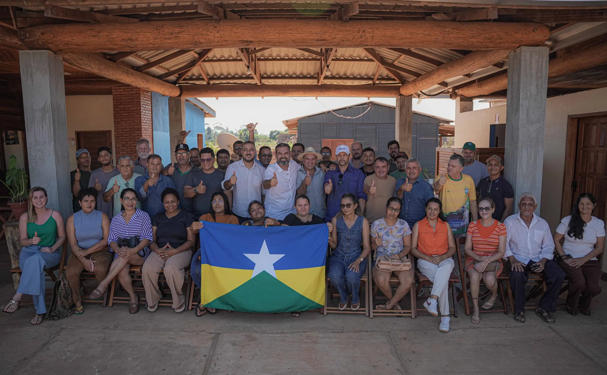 Bruno Scheid com moradores segurando a bandeira de Rondônia